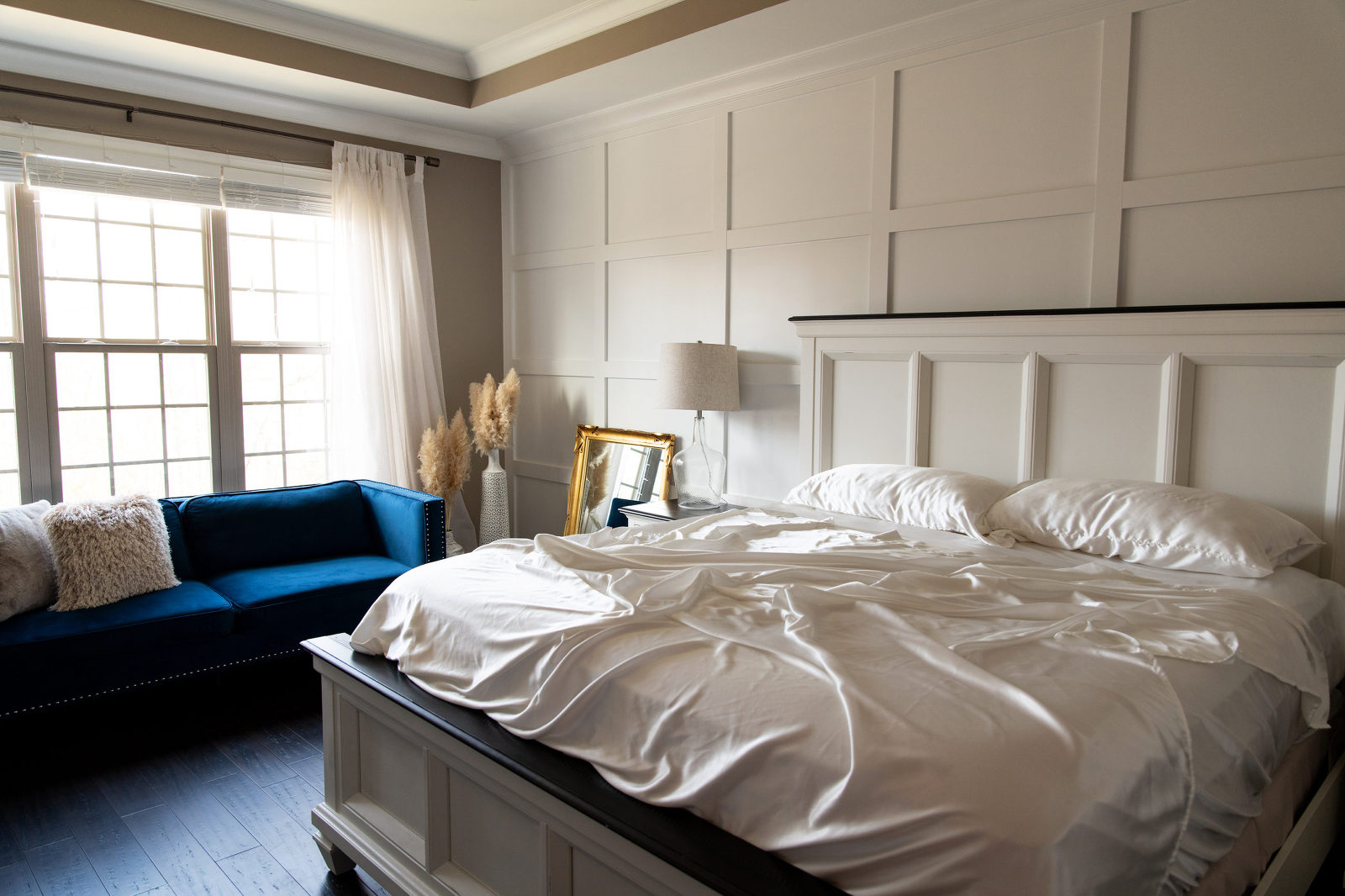 boudoir studio bedroom with white sheets blue sofa white wall king bed